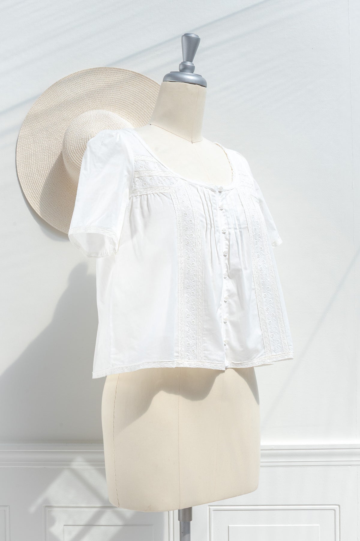 White cotton blouse with lace panels and pintuck pleats three quarter view