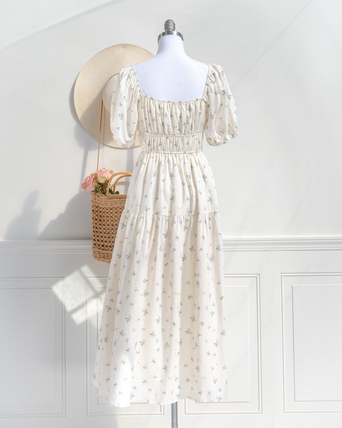 Back view of the cream floral dress, with a square neckline, smocked waist and tiered midi skirt.