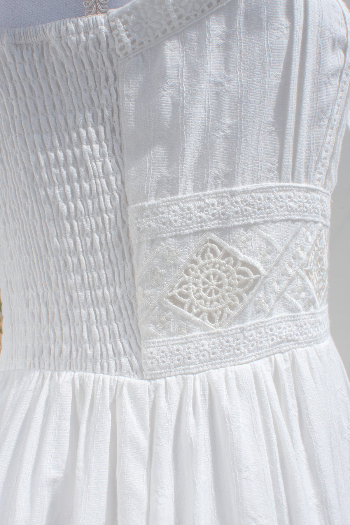 Pintuck embroidery detail on white cotton dress bodice