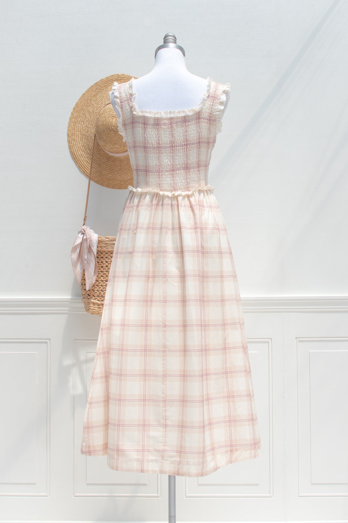 Beige plaid cotton smocked dress displayed on a mannequin, back view.