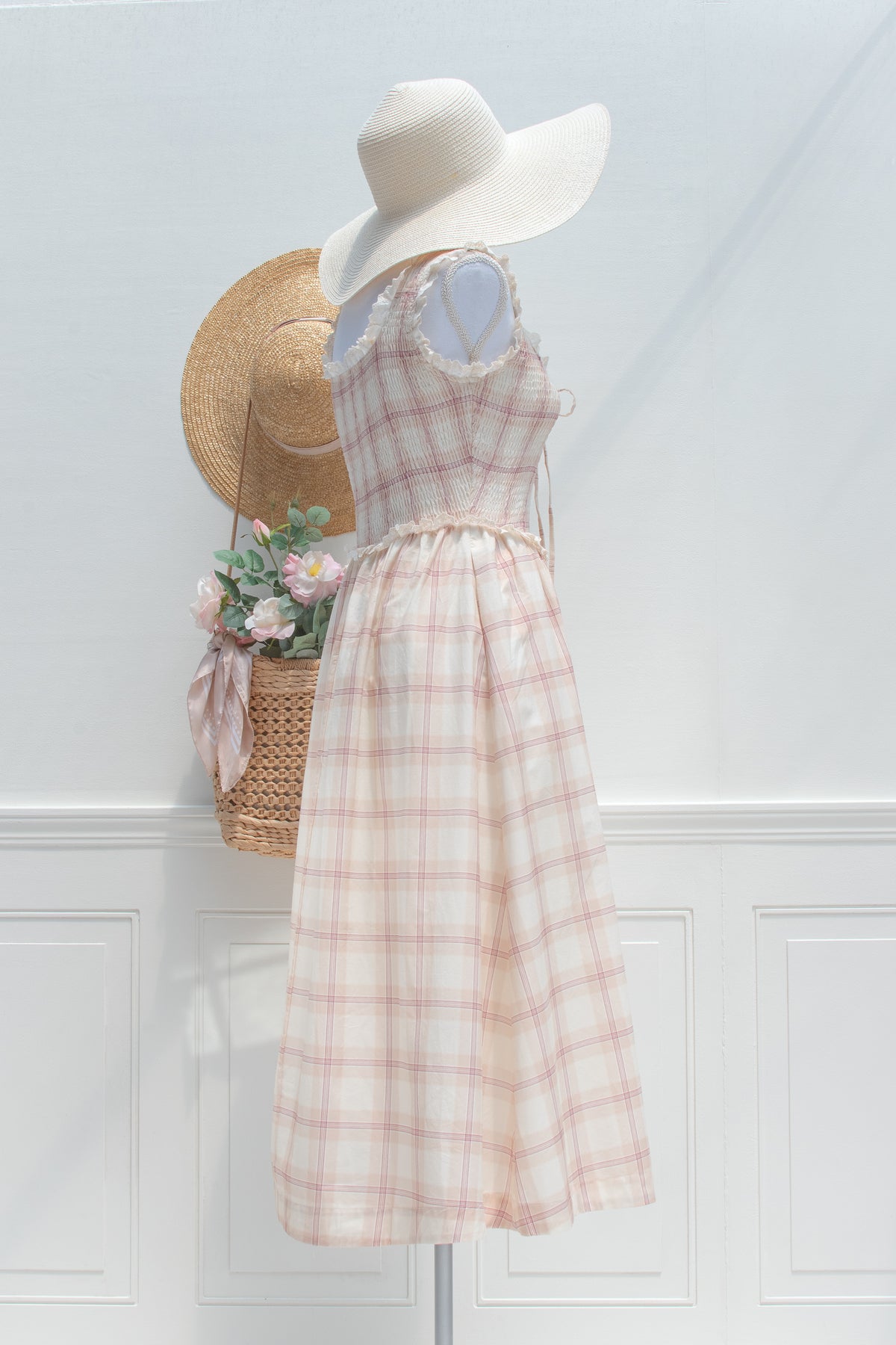 Beige plaid cotton smocked dress styled with a sun hat, mannequin side profile view.