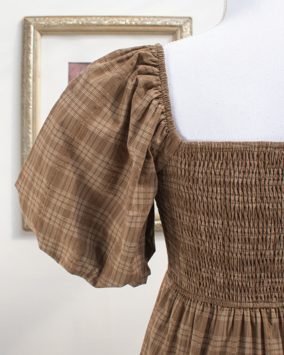 Brown plaid cotton dress with puff sleeve and fully smocked bodice, feminine detail view.