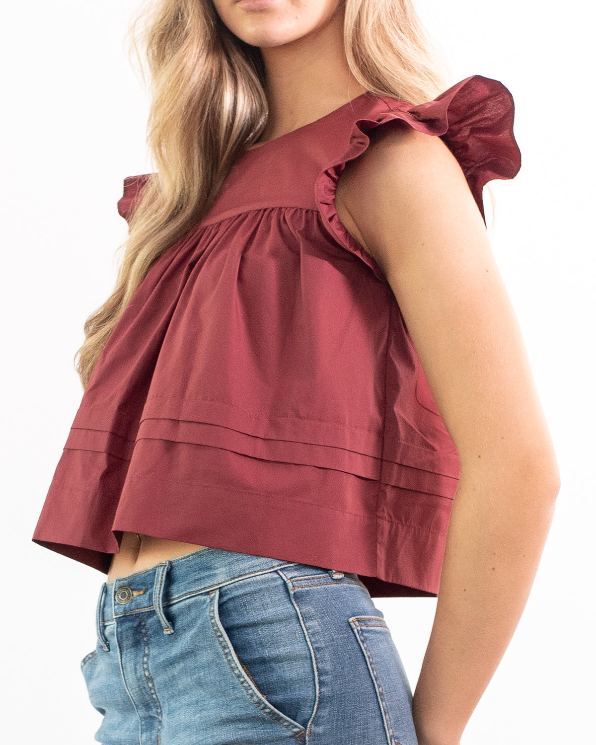 Burgundy cotton cropped top with pintuck hem and flutter sleeves, feminine vintage inspired, three quarter view.