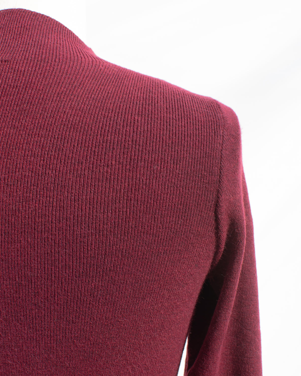 Burgundy knit top with fine ribbed texture and shoulder seam, shoulder detail view.