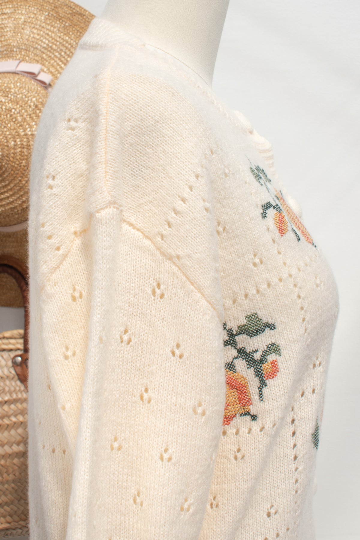 Buttercream knit rose cardigan pointelle stitching shown on the shoulder in close detail.