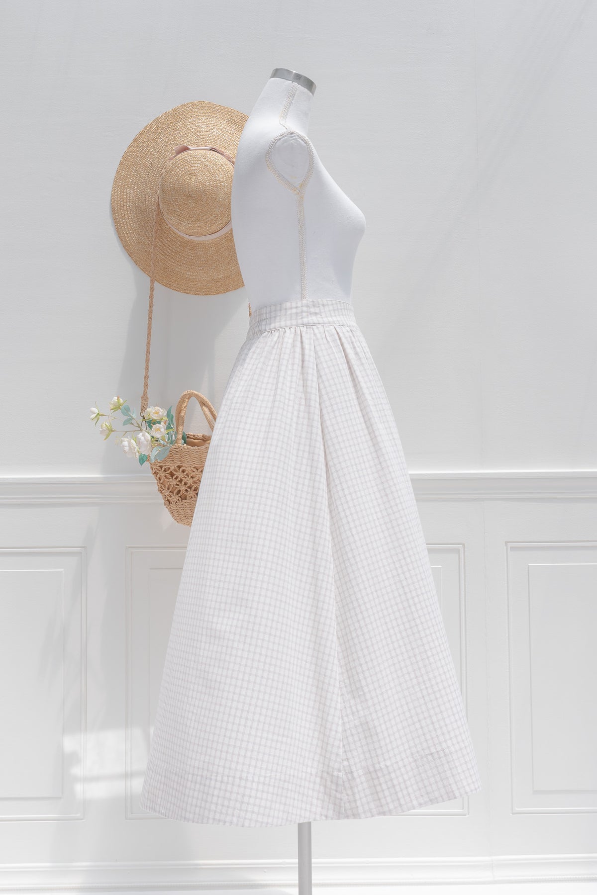 White cotton check midi skirt showing skirt volume and side seam pocket, side view.