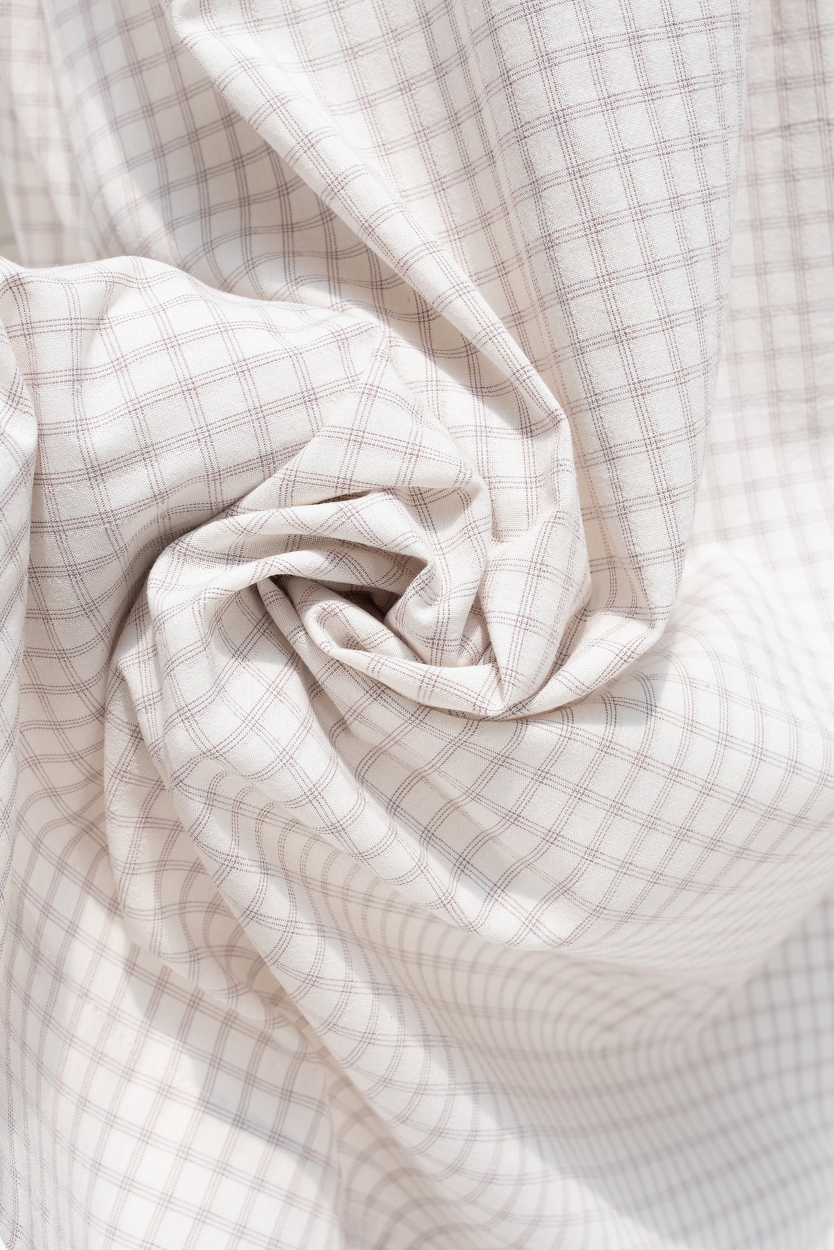 Close up of white and taupe cotton check fabric.