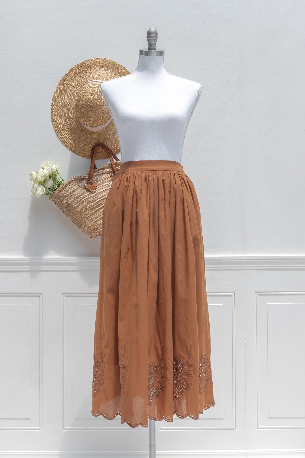 Chestnut cotton midi skirt with embroidered hem, shown on a mannequin, front view.