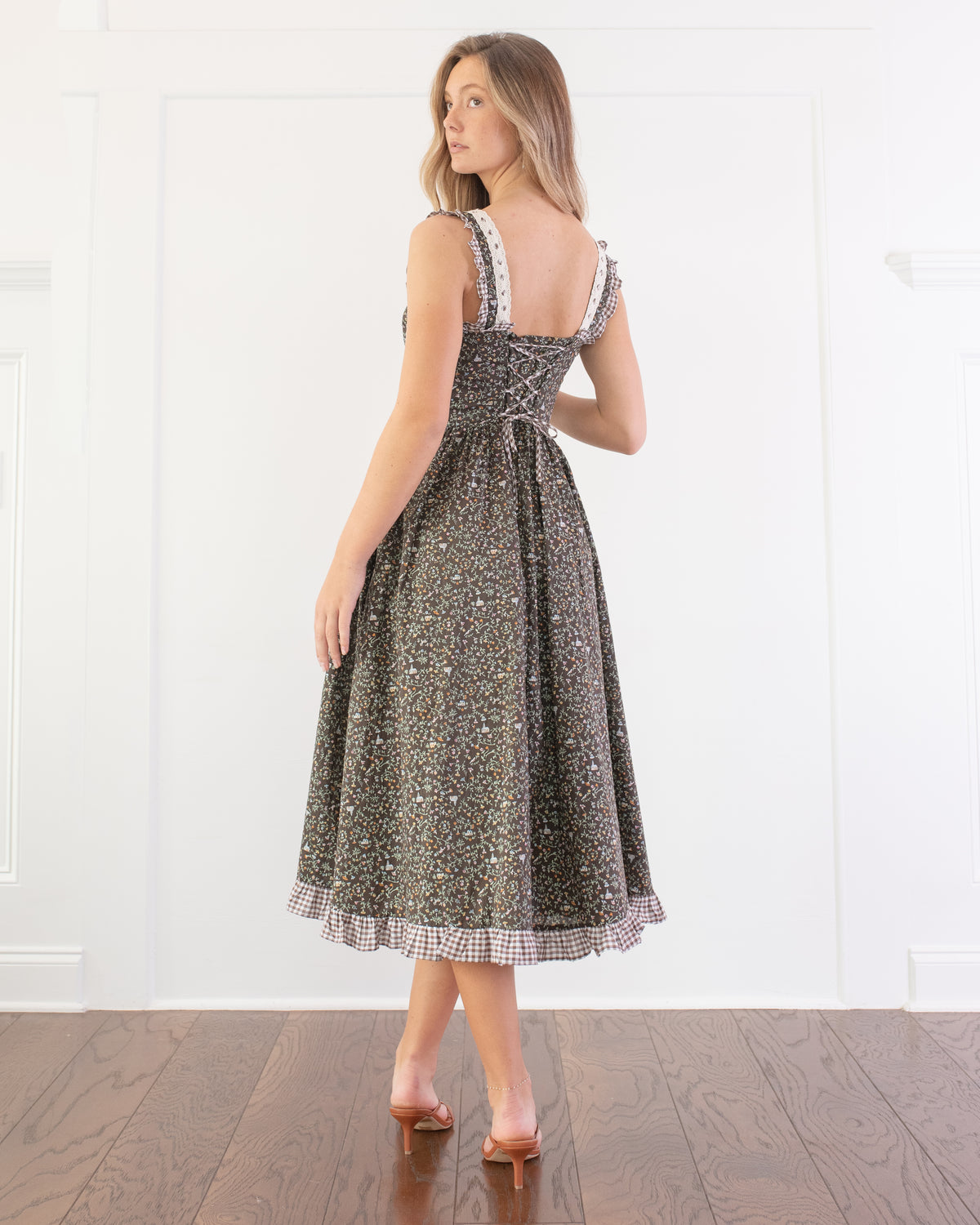 Chocolate brown floral print corset back dress worn by a model, back view.