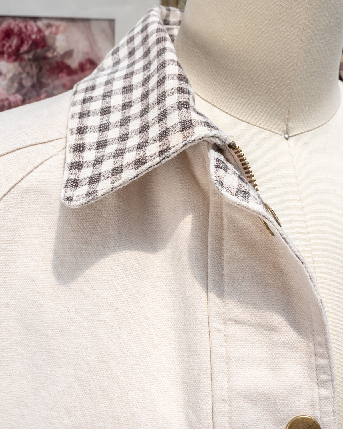 Close-up of the Marlowe Jacket collar in brown and cream gingham, with the brass zipper and snap button against cream cotton canvas.
