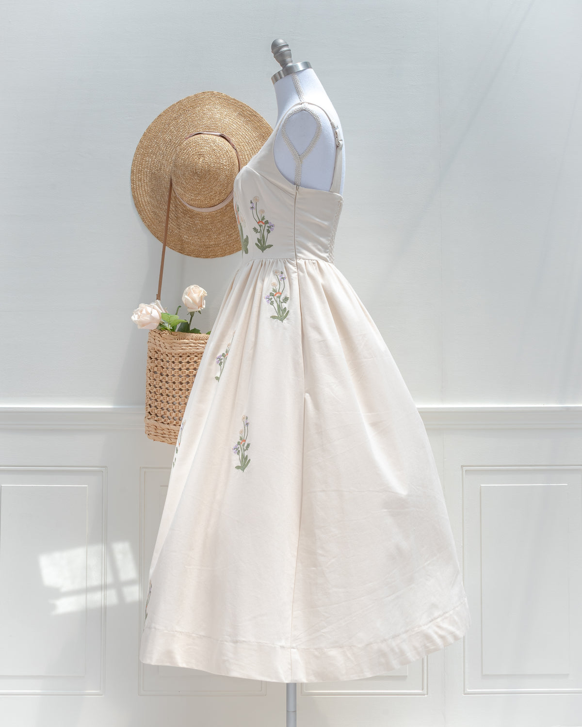 Side view of the cream embroidered midi dress, showing the fitted bodice, side seam zipper and tea-length skirt.