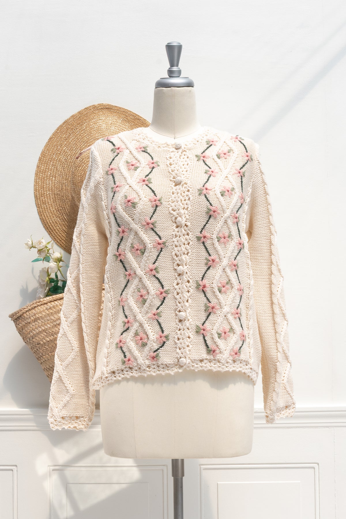 Cream floral embroidered knit cardigan shown buttoned on a mannequin, front view.