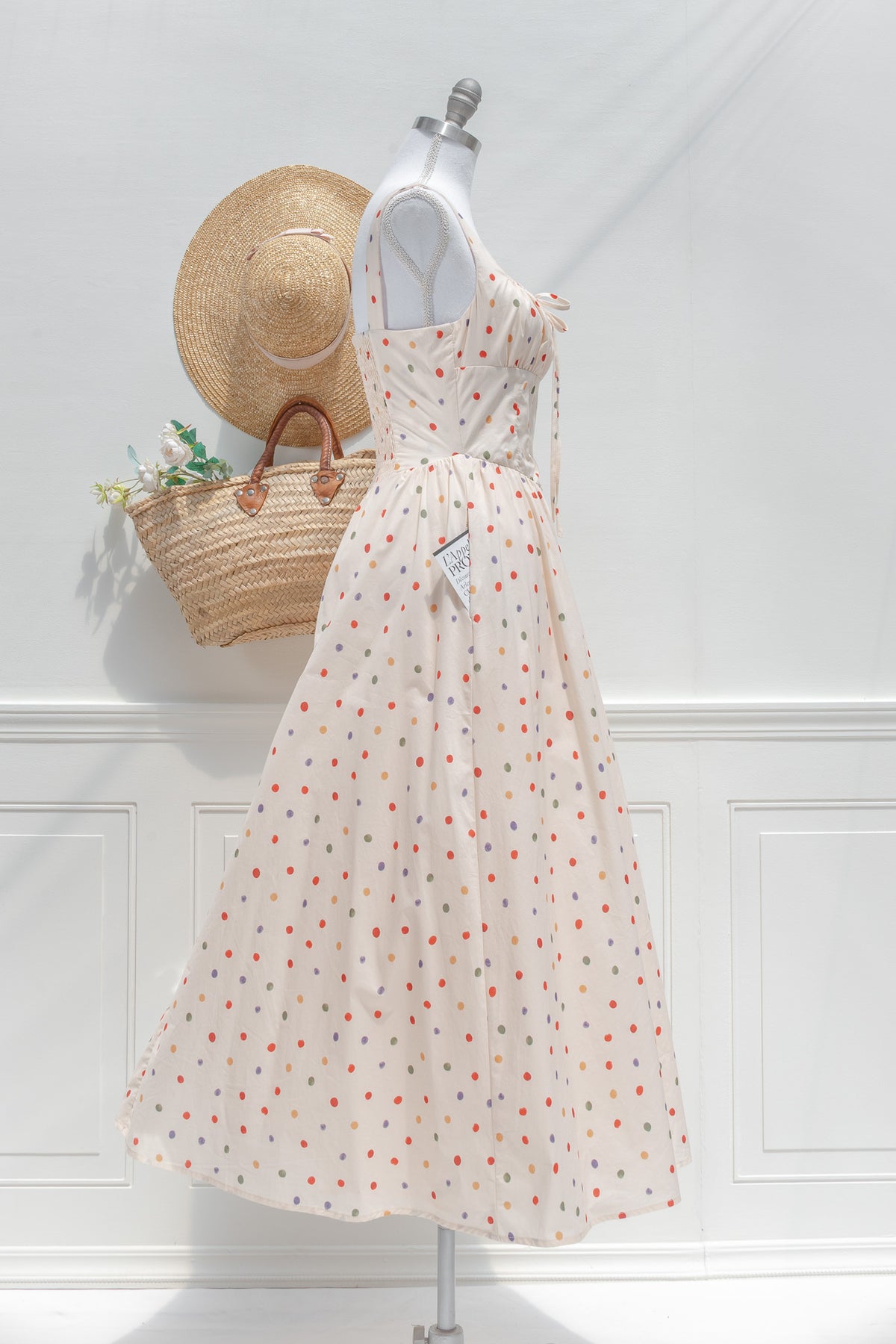 Cream polka dot cotton midi dress with corset bodice structure and full skirt side view.