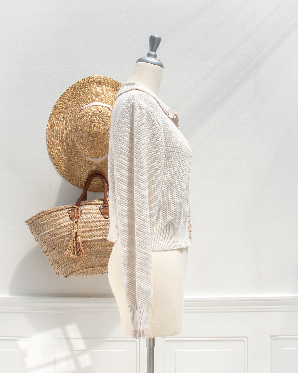 Ivory knit cardigan with ribbed cuff and cropped hem, mannequin side view.