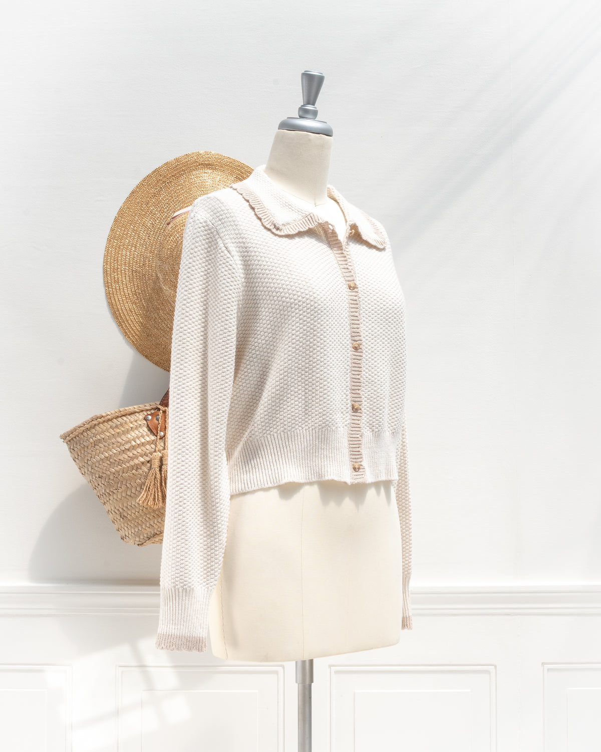 Ivory knit cardigan with tan scalloped collar, a classic cropped layer, mannequin three quarter view.