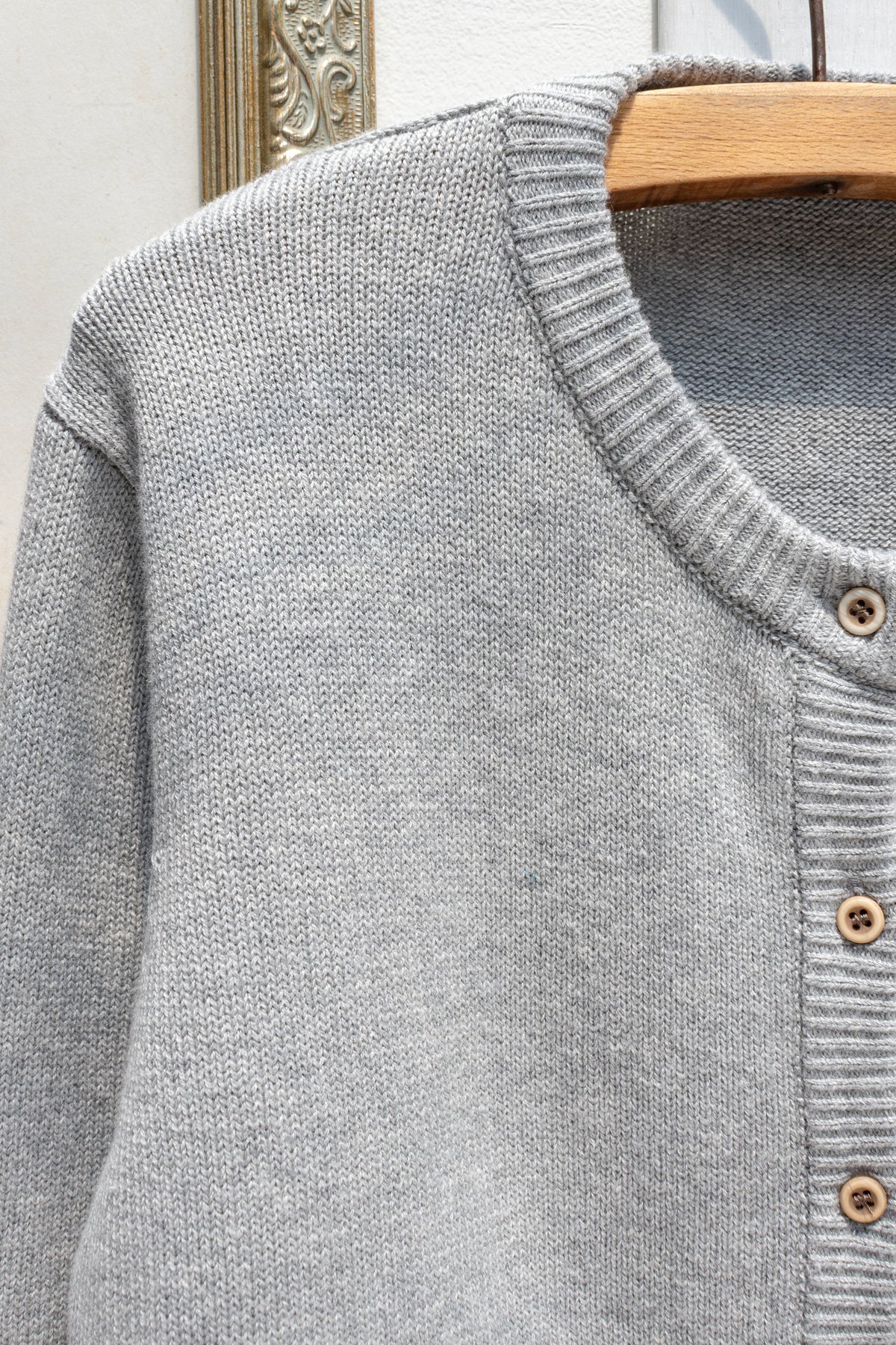 Gray cotton wool cardigan, close up detail of the button front and ribbed collar.