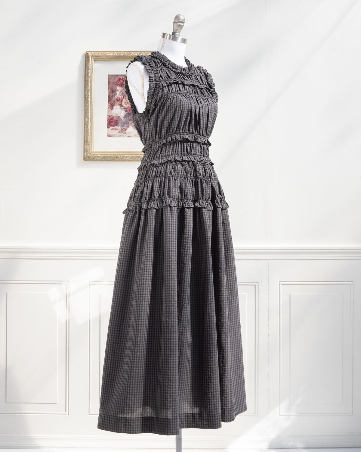 Gray plaid midi dress with ruffled neckline and full skirt on a mannequin, feminine style, three quarter view.