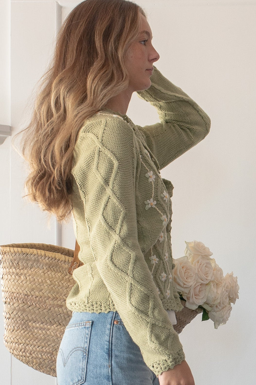 Green knit floral embroidered cardigan, a French girl essential, on a model, side view.