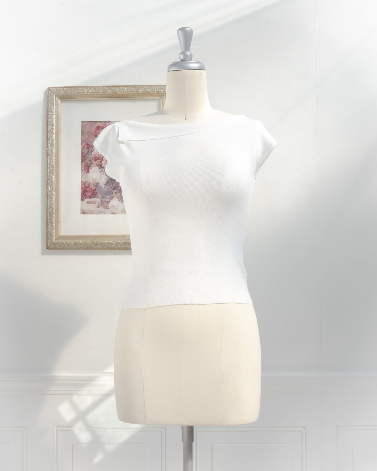 Ivory knit top with foldover boat neckline and cap sleeves on a mannequin, French girl style, front view.