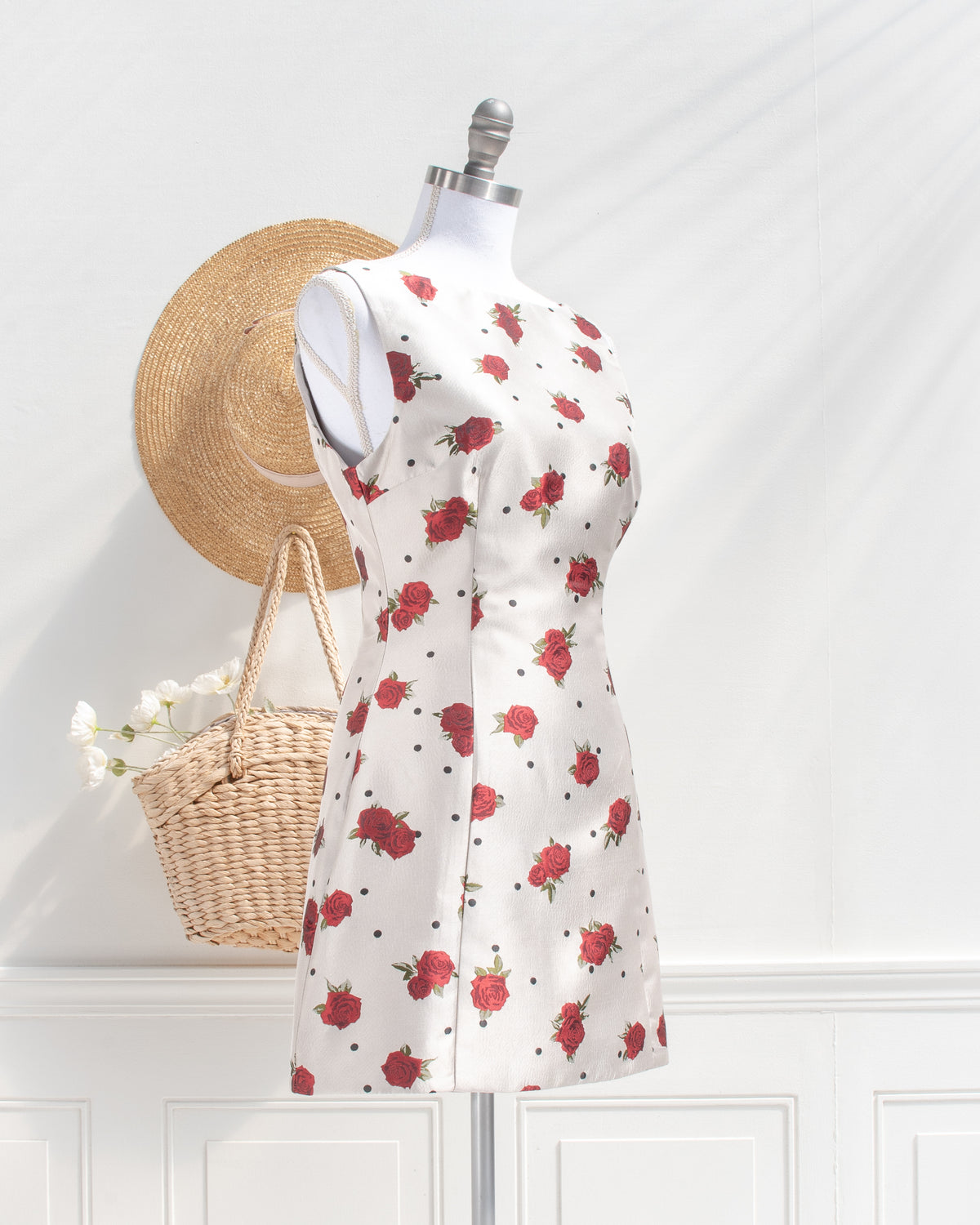 Ivory rose and polka dot mini dress with a fitted silhouette on a mannequin, vintage inspired, three quarter view.