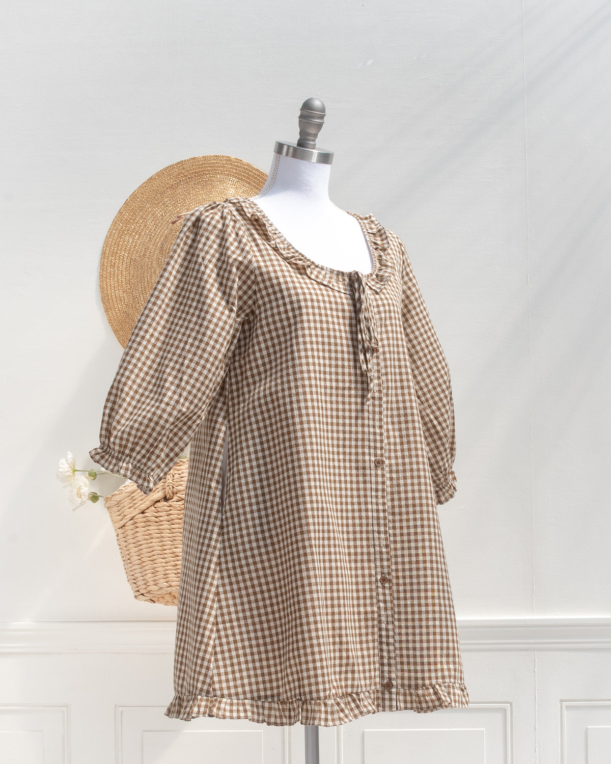 Brown gingham mini dress with ruffle collar and gathered sleeves, mannequin three quarter view