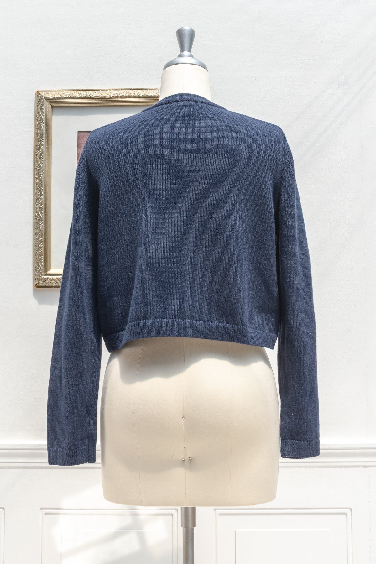 Navy cotton wool cropped cardigan displayed on a mannequin, back view.