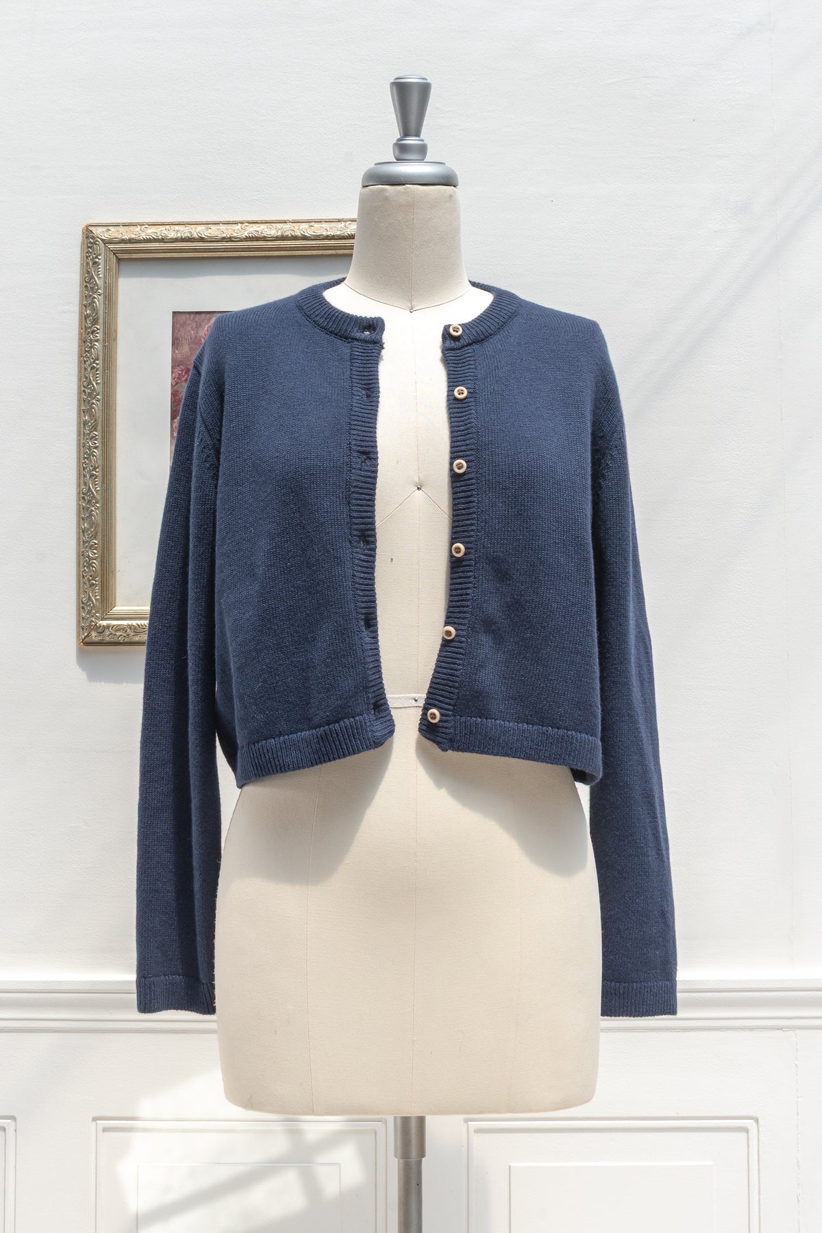 Navy cotton wool cropped cardigan displayed open on a mannequin, front view.