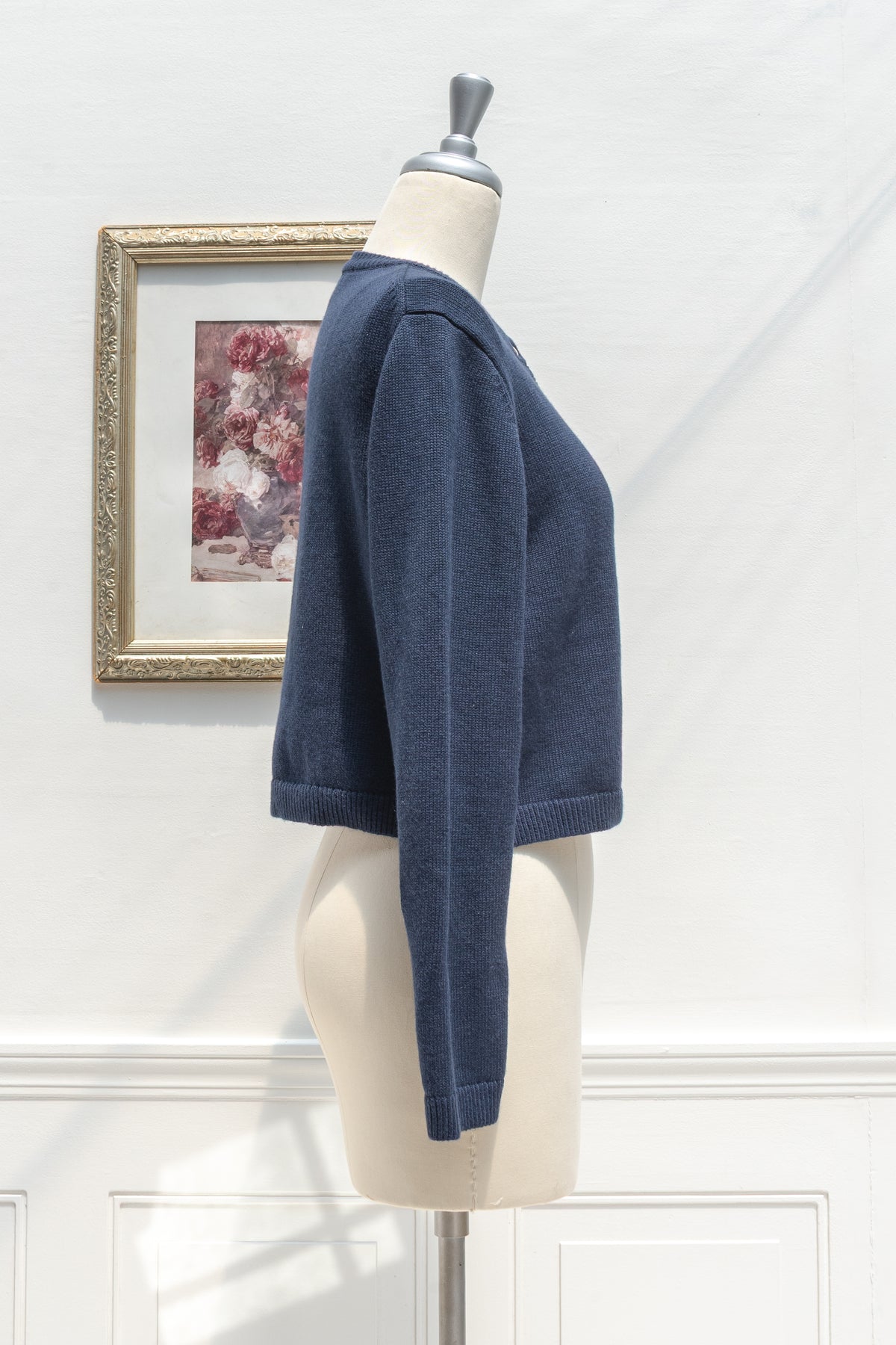 Navy cotton wool cropped cardigan displayed on a mannequin, side profile view.