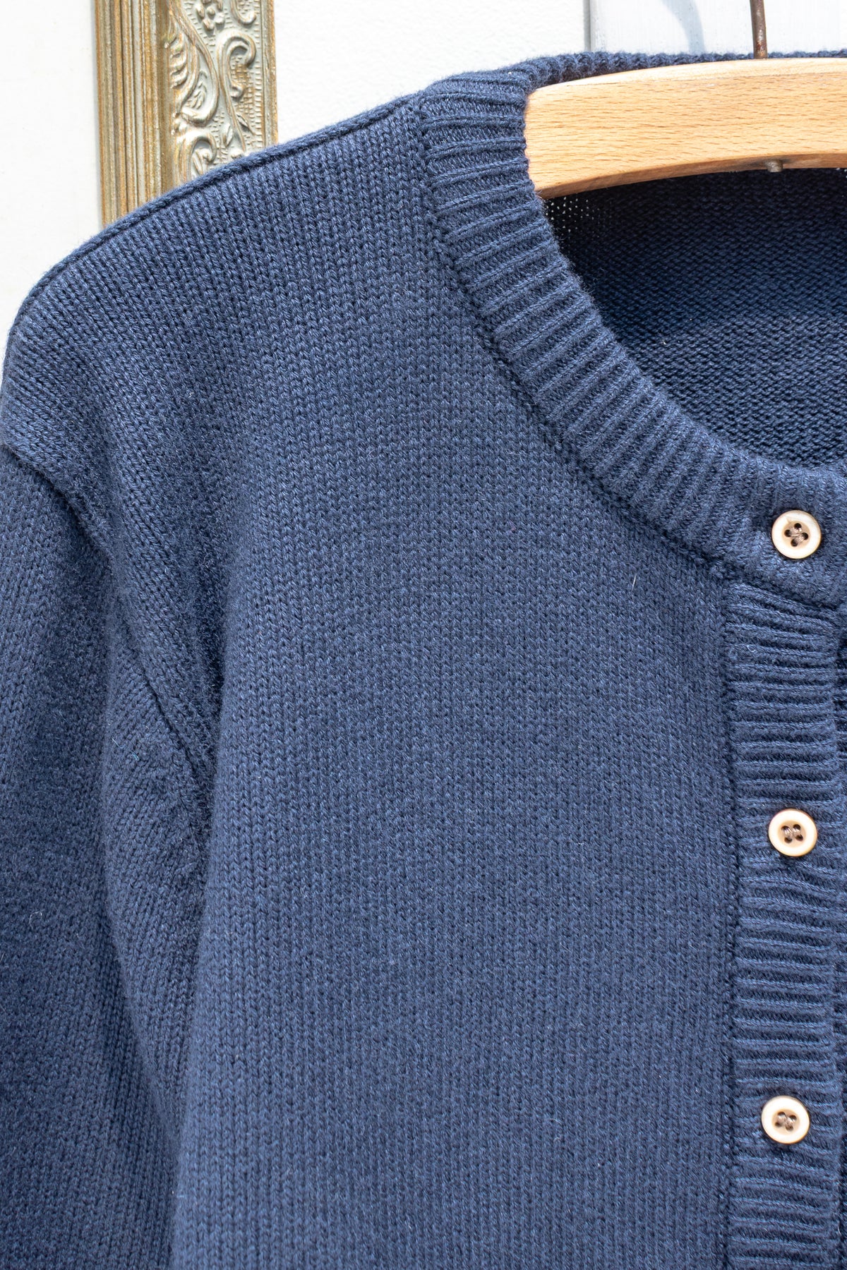 Navy cotton wool cardigan, close up detail of the button front and ribbed collar.