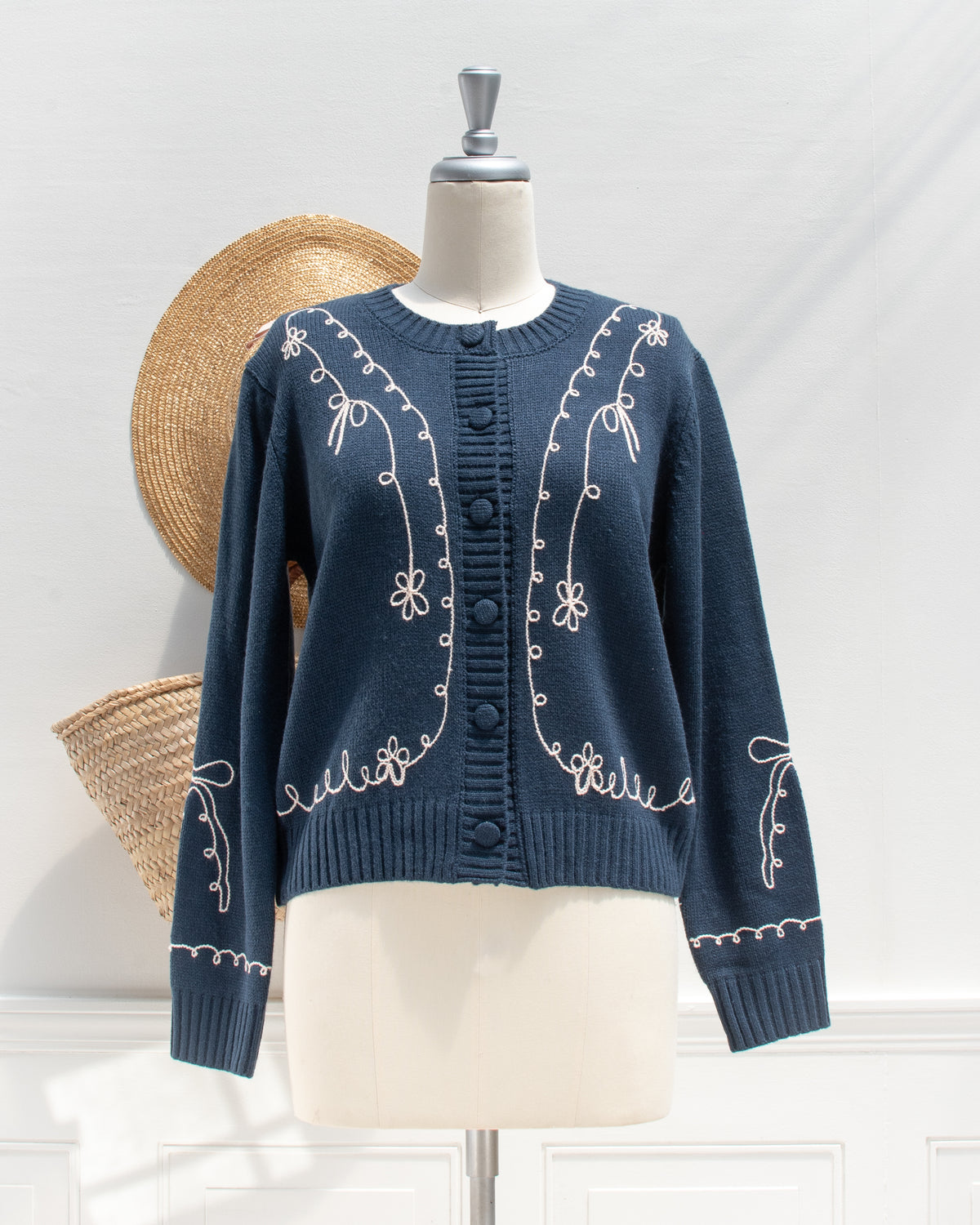 Feminine style cardigan. French girl style. Blue cardigan with whimsical bow detail embroidery. Front view. Amantine