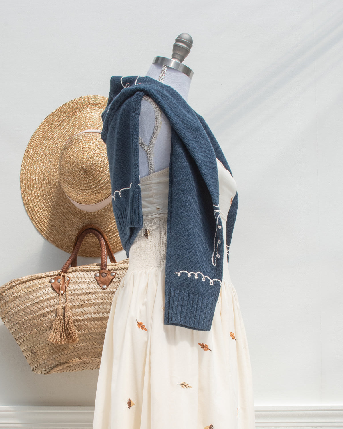 Feminine style cardigan. French girl style. Blue cardigan with whimsical bow detail embroidery. styled over a feminine midi dress view. Amantine