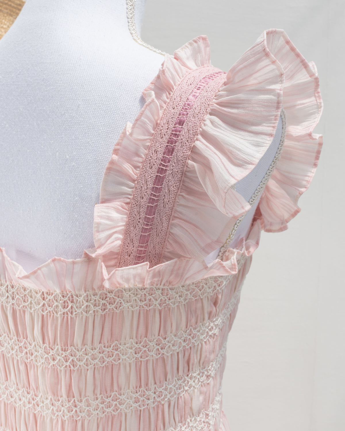 Blush pink striped dress with ruffled lace strap and smocked bodice, feminine romantic French girl style, detail view.