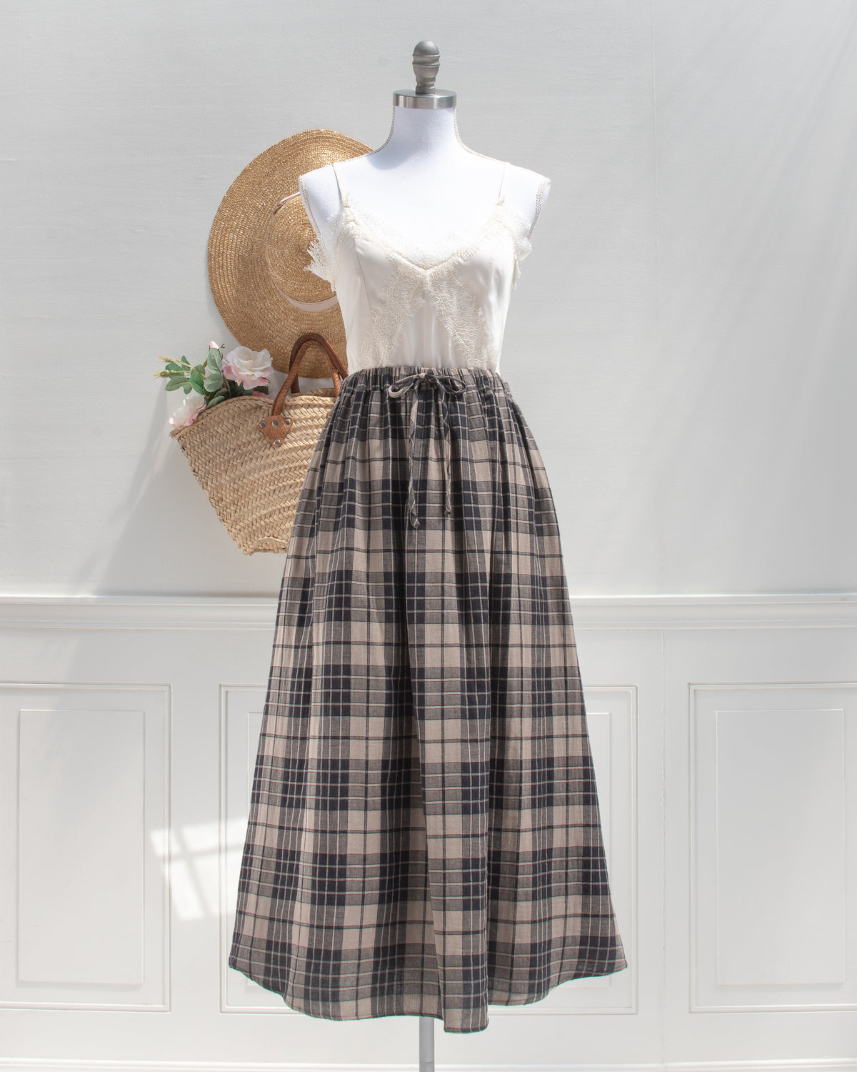 Tan and black plaid cotton midi skirt with drawstring waist and lace cami, a feminine staple, mannequin front view.