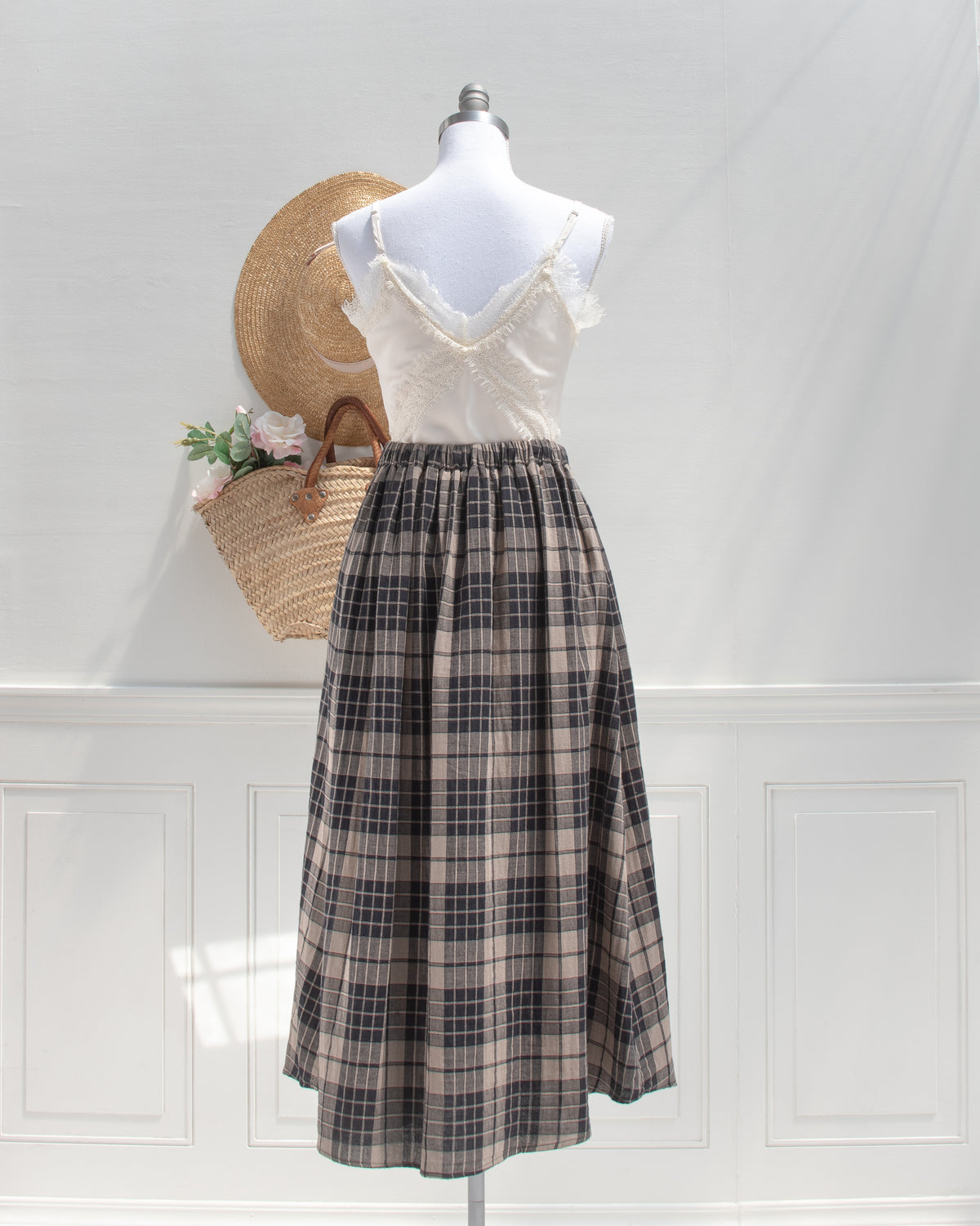Tan and black plaid cotton midi skirt styled with a lace cami, a French girl essential, mannequin back view.