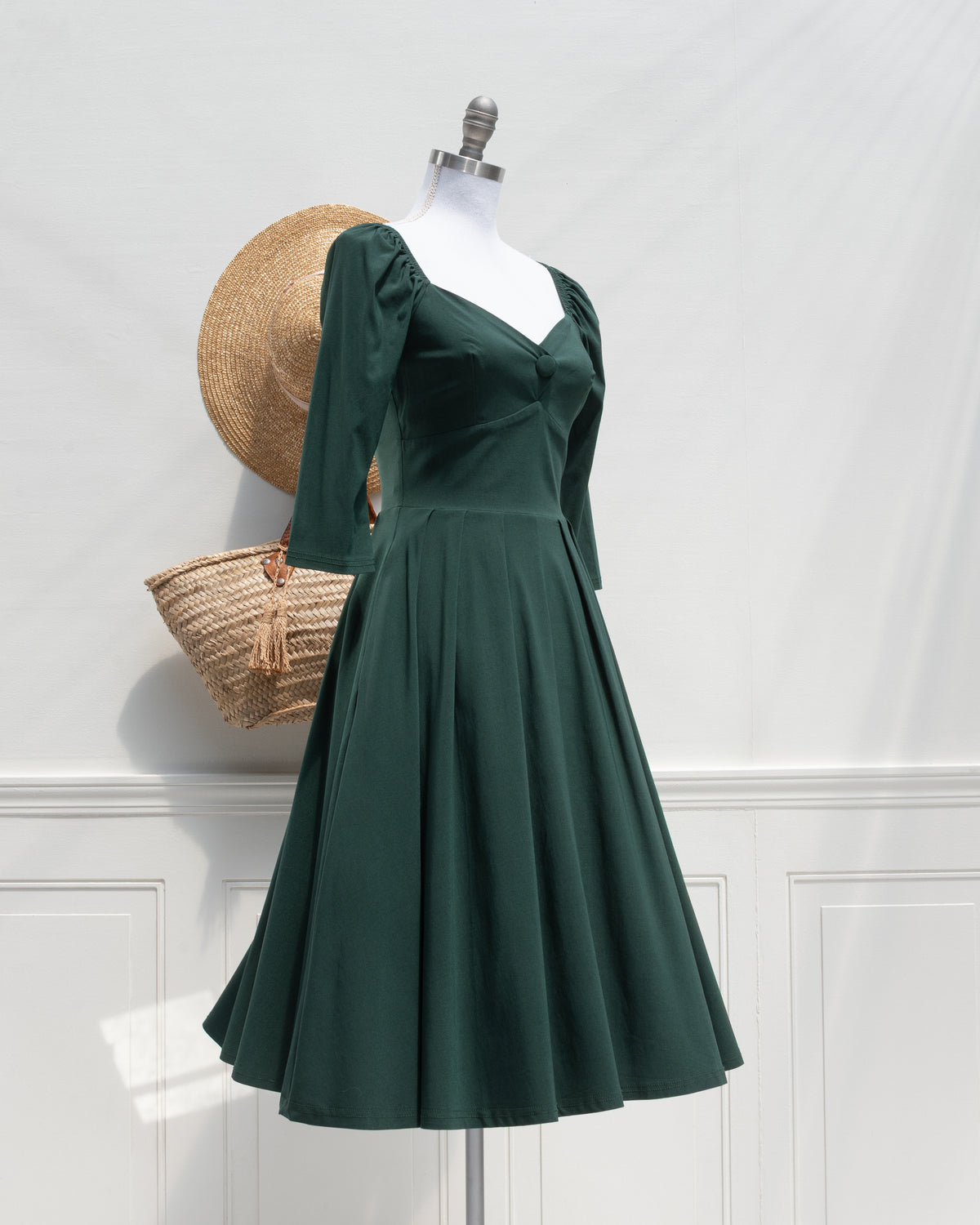 Green Retro Swing Dress. In French vintage style with modern ease featuring a sculpted sweetheart neckline, softly gathered shoulders, and a full swing skirt. 3/4 side view. Amantine