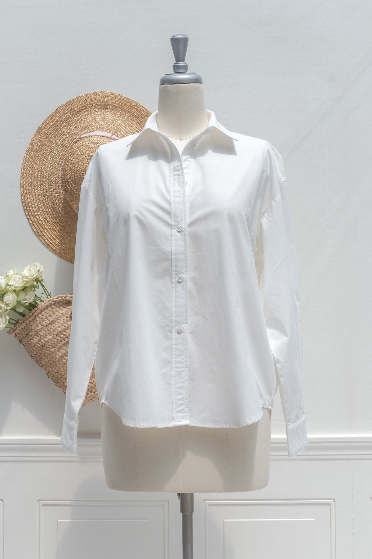 White cotton button up shirt shown on a mannequin, front view.