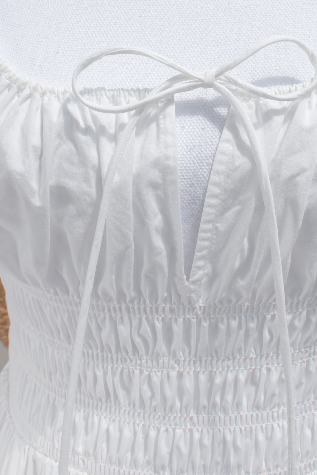 close up of drawstring neckline and smocked waist