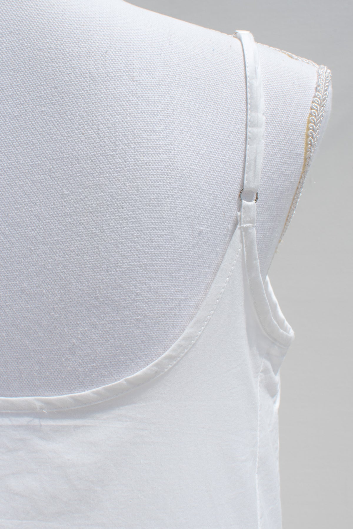 White cotton fabric and spaghetti strap close up.