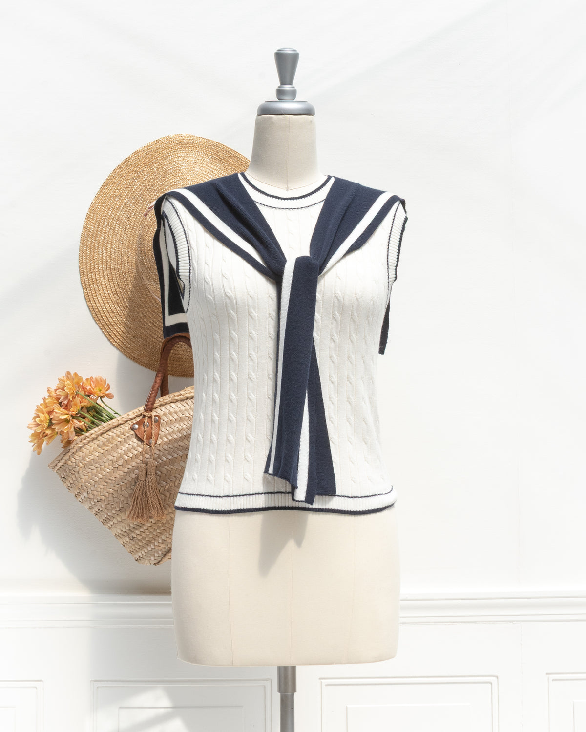 White cable knit sailor top with navy tie collar, a classic wardrobe staple, mannequin front view.