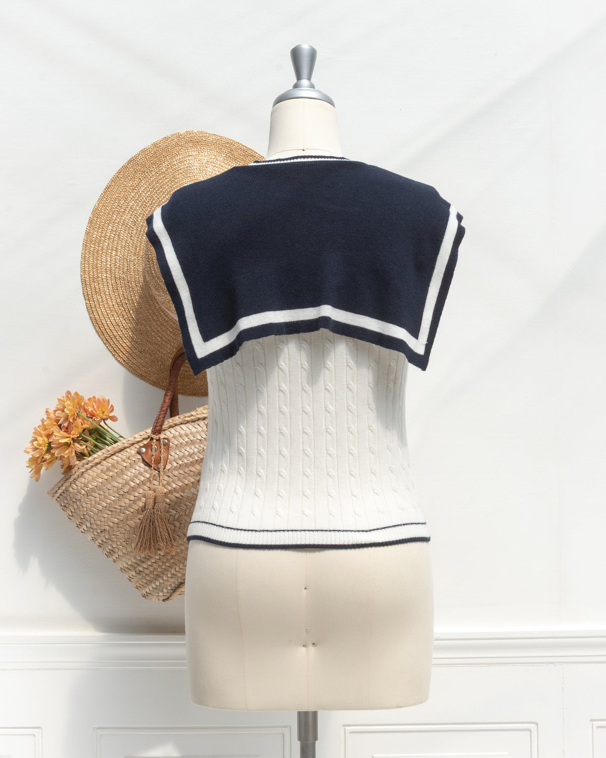 White cable knit sailor top with navy sailor collar, mannequin back view.