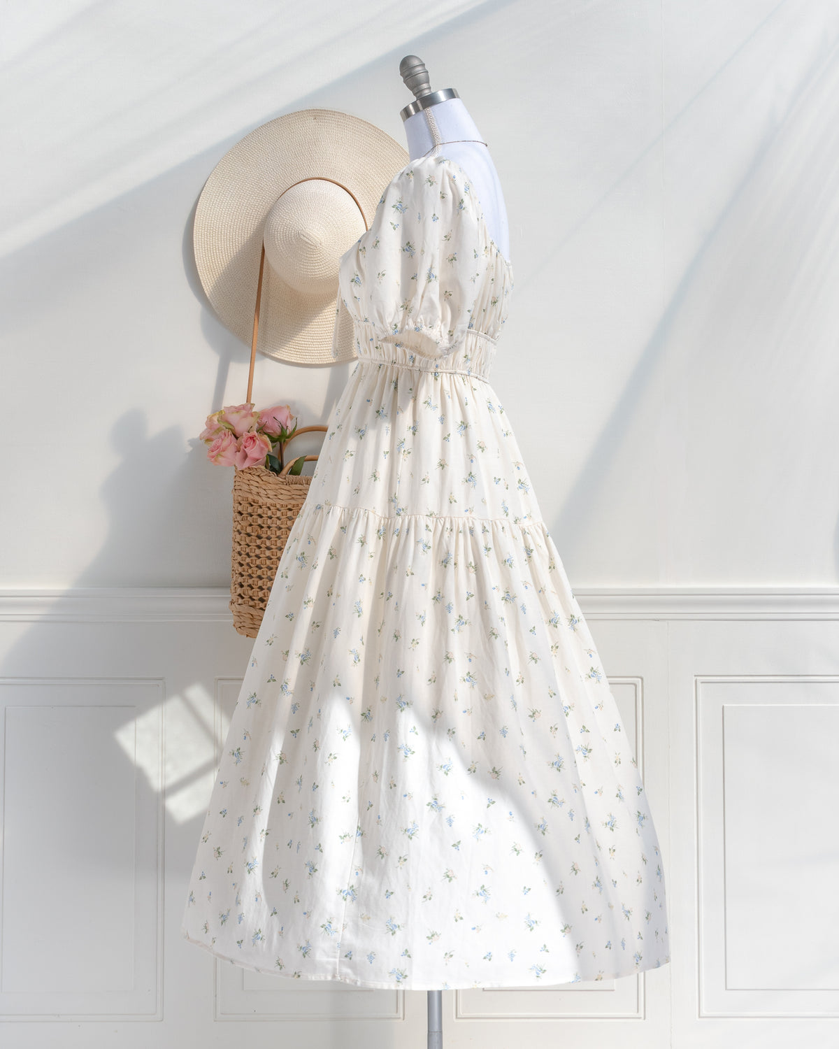 Side view of the cream floral dress, showing the puff sleeve, smocked waist and tiered midi skirt.