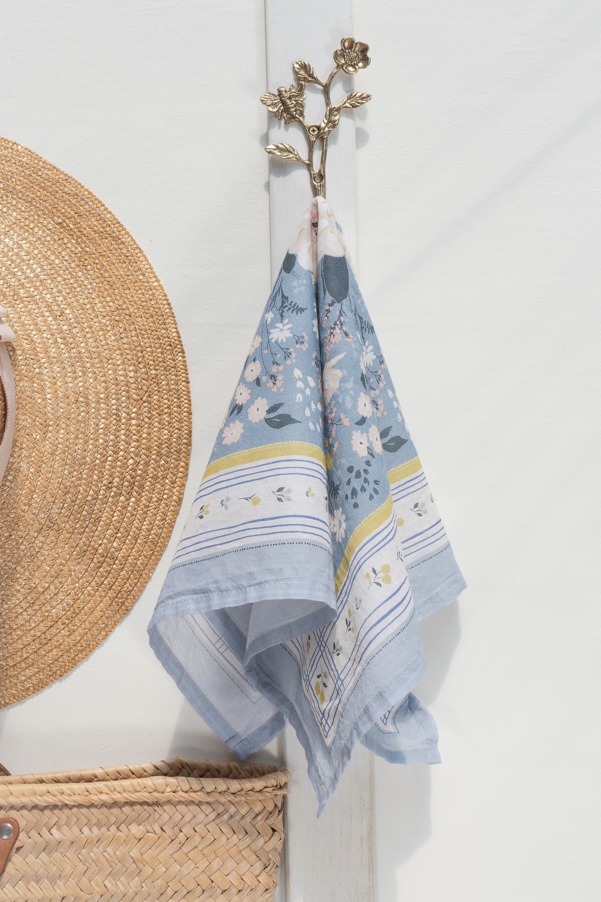 Blue floral cotton scarf shown hanging, full view.