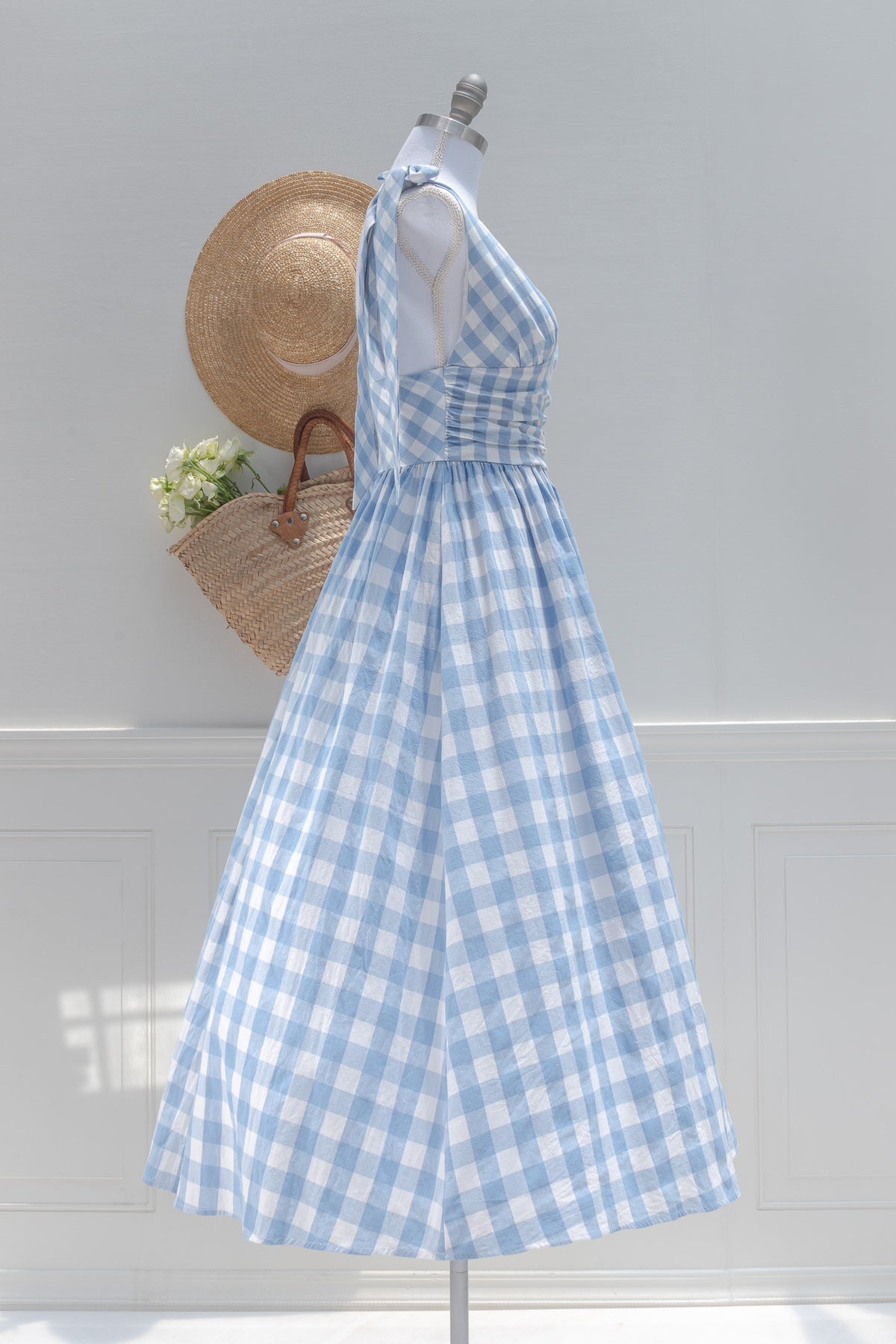 Blue and white gingham midi dress with a ruched waist, shown on a mannequin, side view.