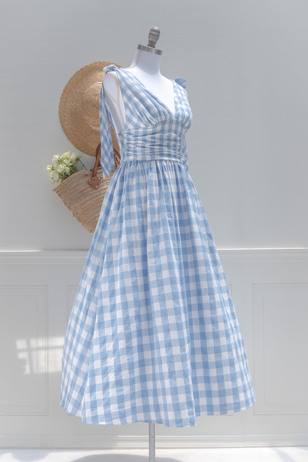 Blue and white gingham midi dress shown on a mannequin, three quarter view.