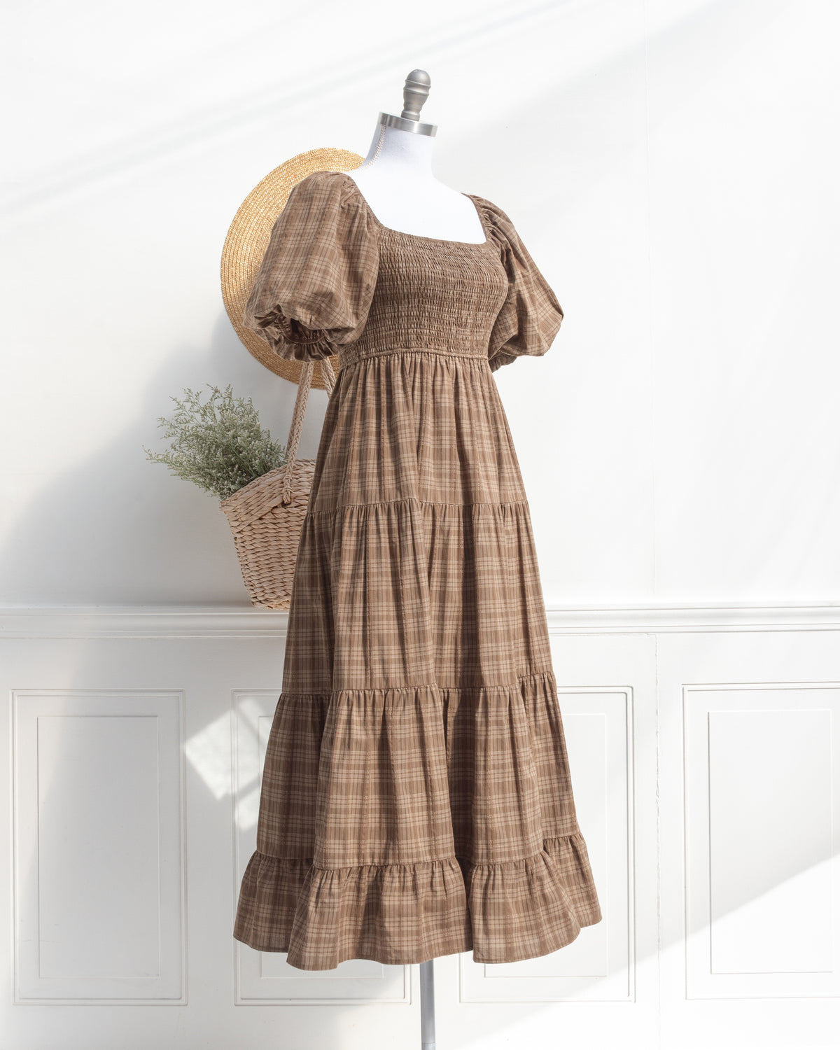 Brown plaid cotton midi dress with puff sleeves on a mannequin, feminine vintage inspired, three quarter view.