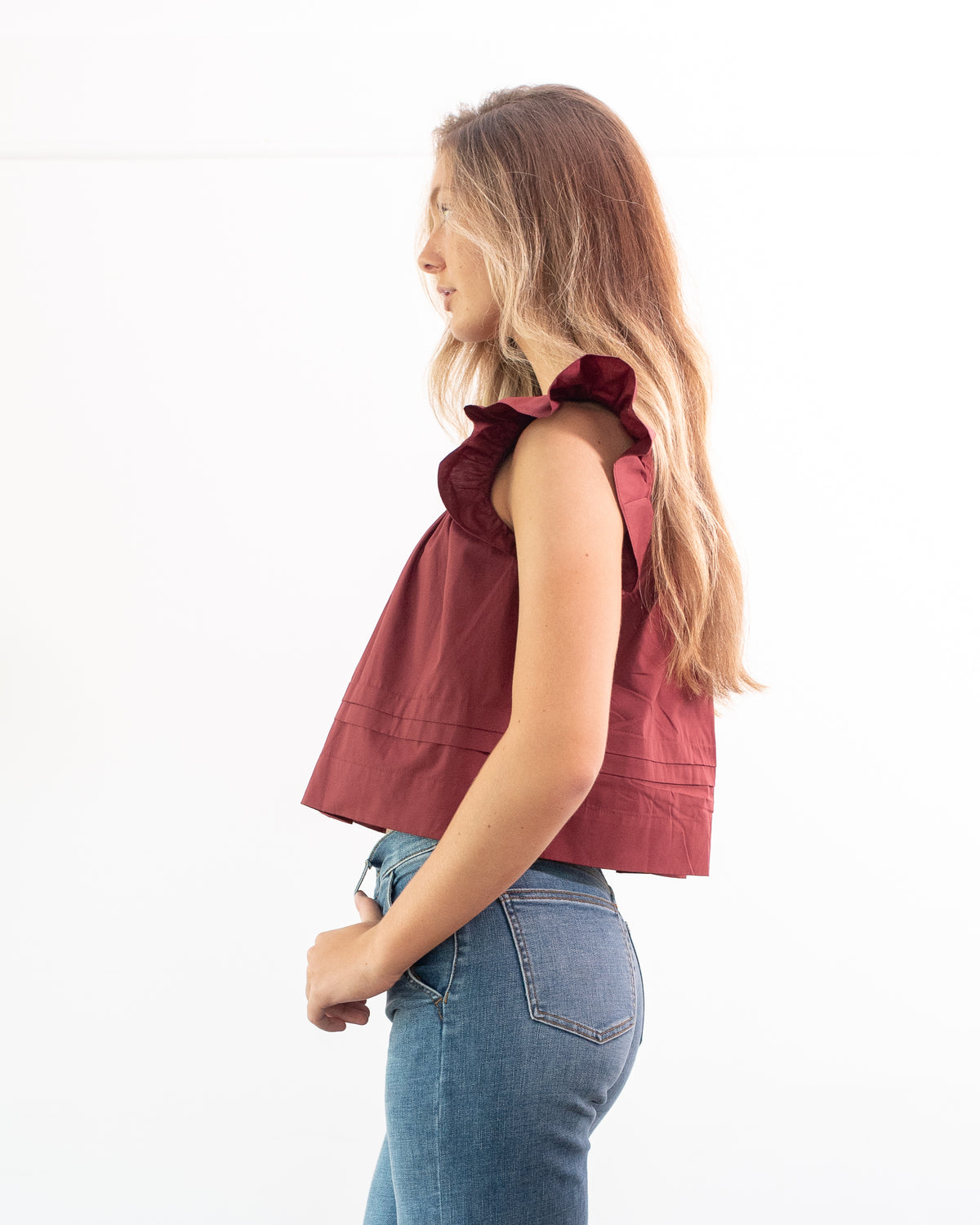 Burgundy cotton flutter sleeve top with a gathered yoke and relaxed cropped fit, side view.