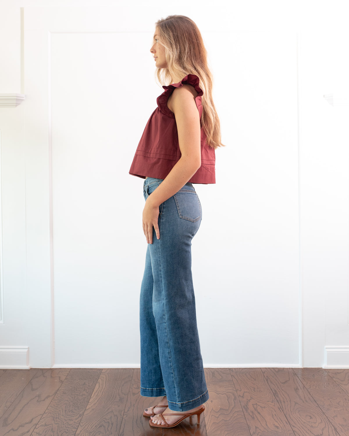 Burgundy cotton flutter sleeve top, classic cropped fit styled with wide leg jeans and heels, full length side view.