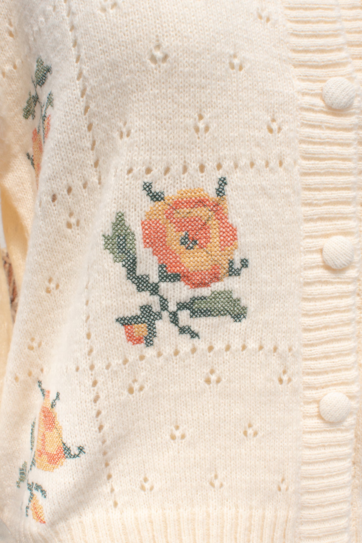 Buttercream knit rose cardigan floral embroidery shown in close detail.