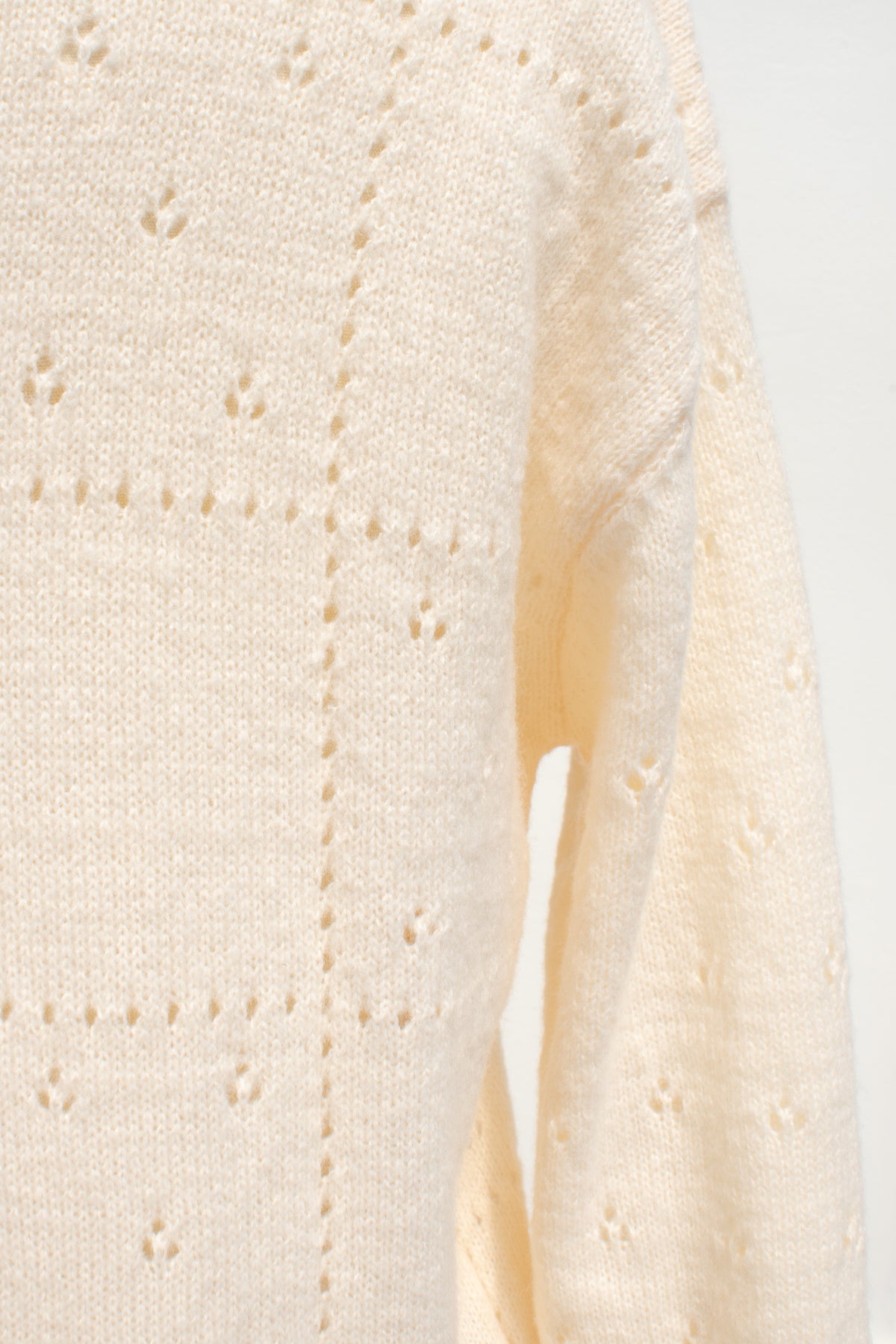 Buttercream knit rose cardigan pointelle stitch texture shown in close detail.