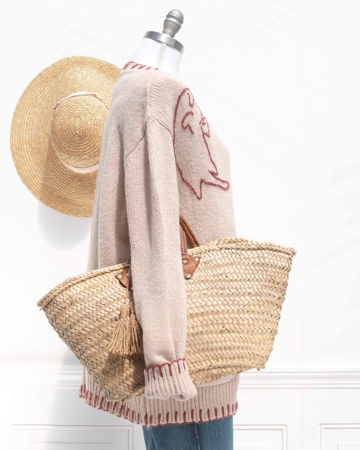 Blush knit cardigan styled with a woven basket bag, a French girl style fall layer, mannequin side view.